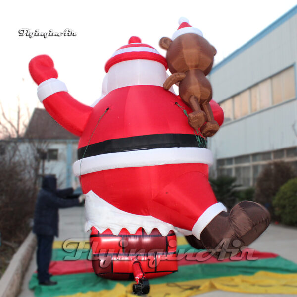 inflatable santa with bear sitting on the chimney