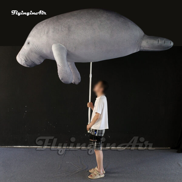 holding inflatable manatee puppet blow up sea animal balloon for event