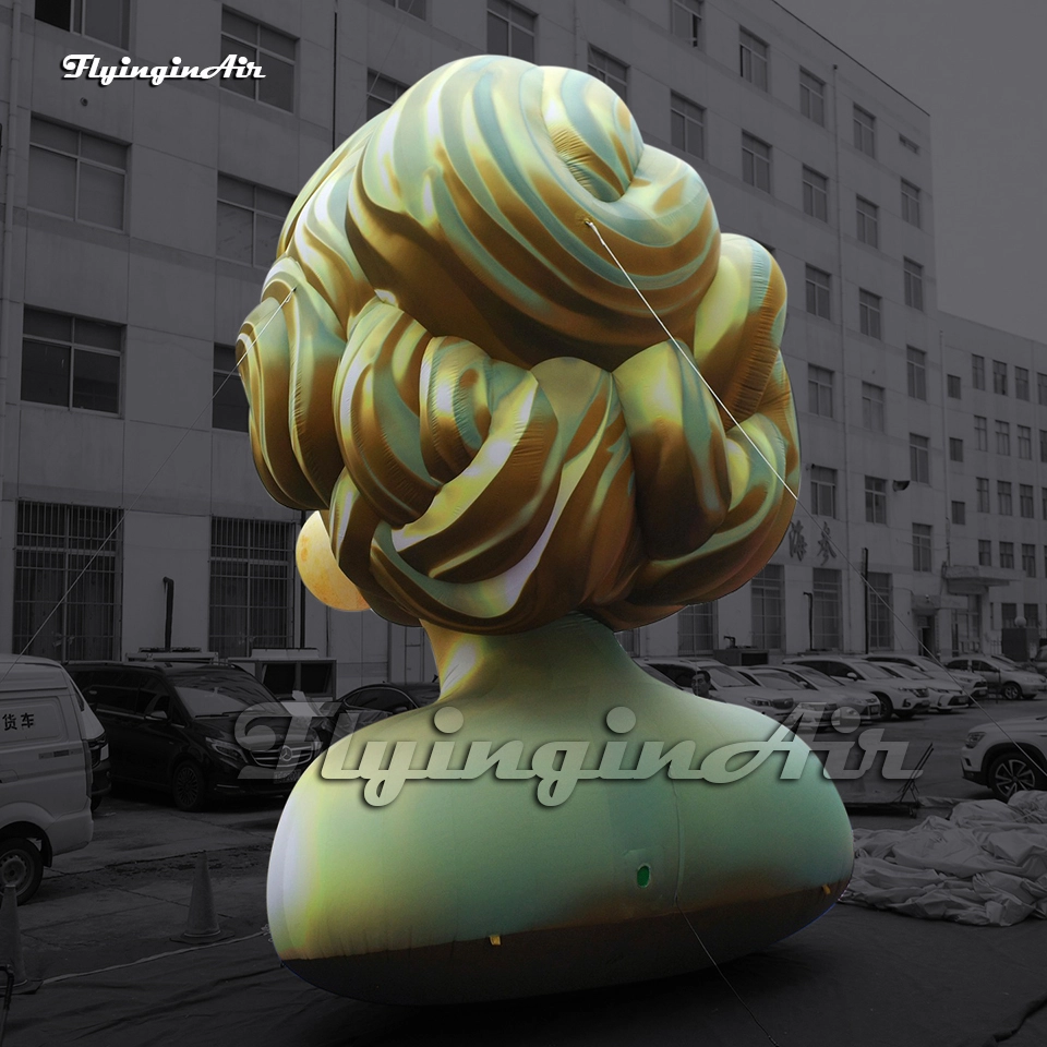 Back view of a giant inflatable golden woman bust sculpture with a moon balloon bubble